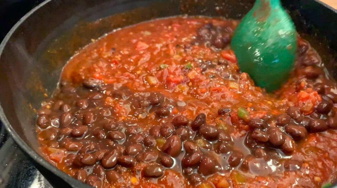 adding canned ingredients to chili