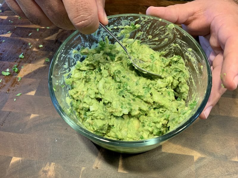 mixing homemade guacamole