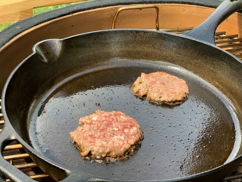 hamburgers in a cast iron on the grill