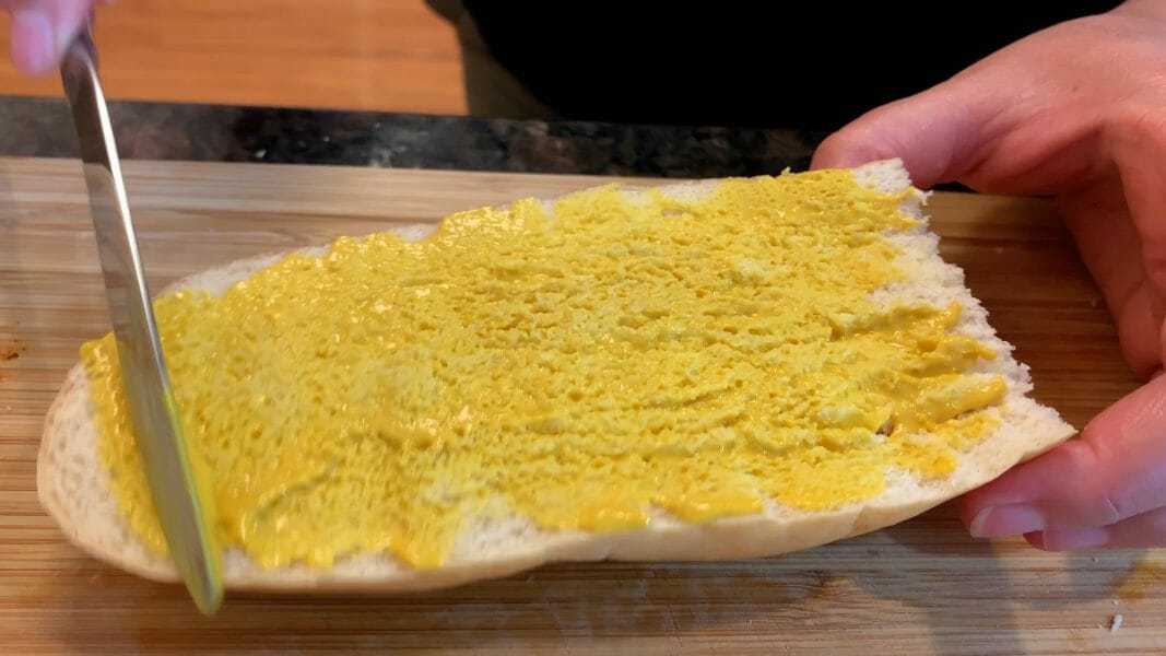 spreading mustard on the bread