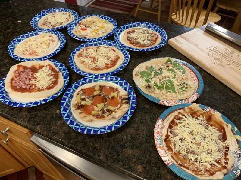 9 different pizzas ready to head to the grill