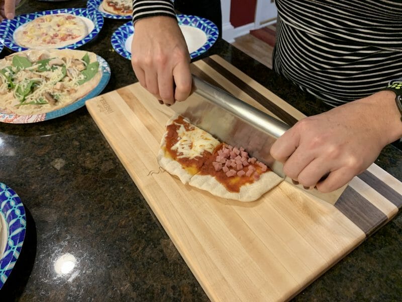 cutting grilled pizza into slices