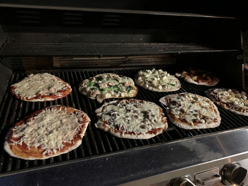 eight pizzas on the grill