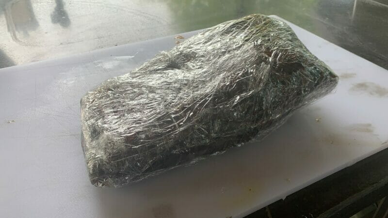 smoked brisket wrapped in butcher paper wrapped in plastic wrap for the rest