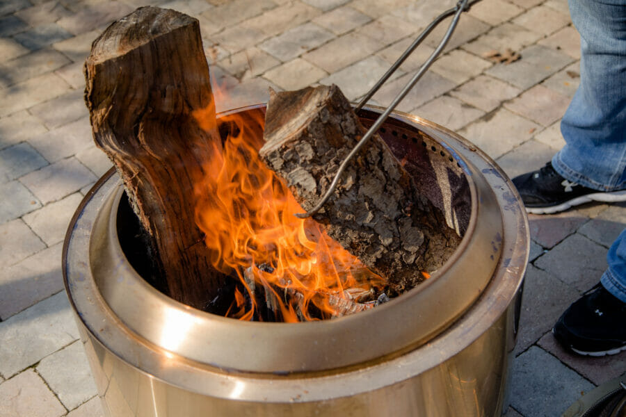 Adding new logs to the hot coals in the Solo Stove Yukon