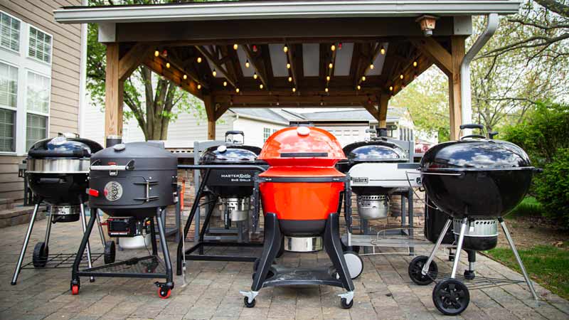 6 charcoal grills lined up for best kettle grill testing on the patio