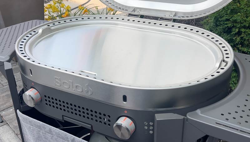 griddle-top The stainless steel top of the Steelfire griddle with peep holes above each burner knob
