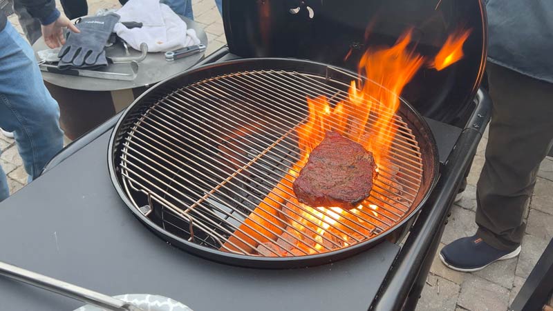 SnS Master Kettle searing a steak over charcoal