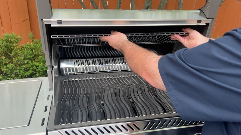 The stainless steel warming rack stowed away above the infrared rotisserie burner