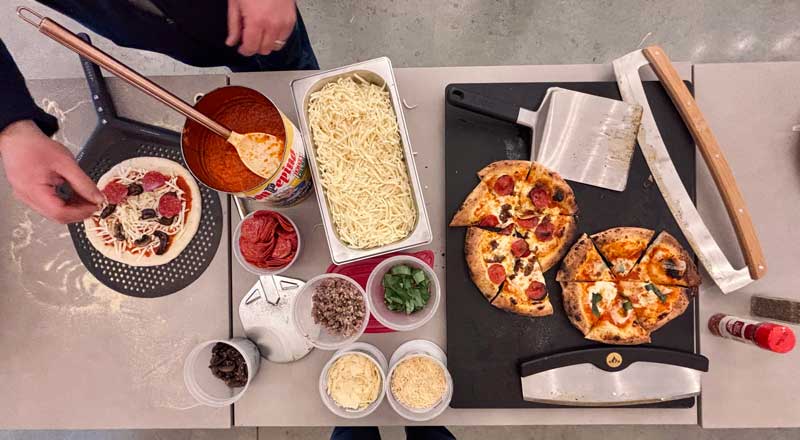 pizza-station building pizzas to cook in the Arc Lite propane pizza oven