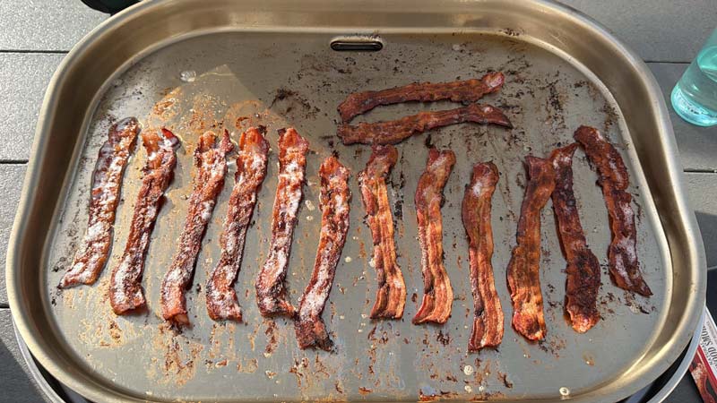 steelfire-22-5 1 pound of bacon cooking on the portable Steelfire 22 cooking surface