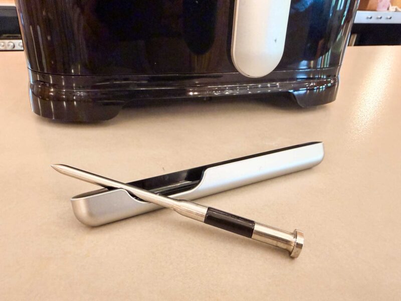 The Sync air fryer meat thermometer probe monitors temperature in cooked steaks or roast whole chicken