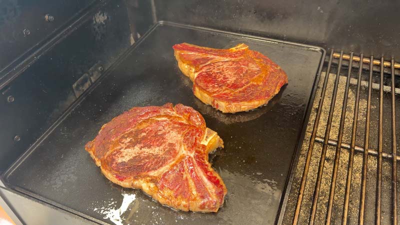reverse seared ribeyes smoked on a pellet grill and seared on the griddle accessory
