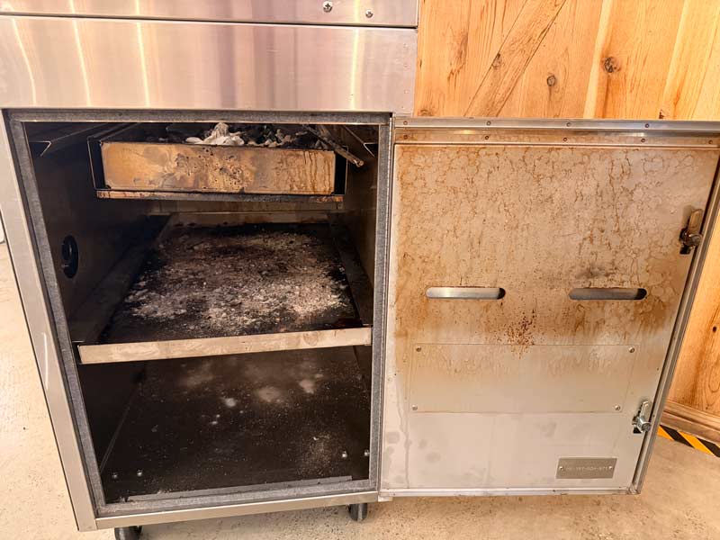 The charcoal and ash pans are located inside the fire box of the Hasty Bake 357 Pro.