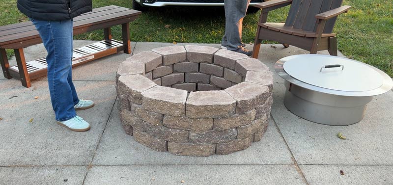 Breeo Zentro sitting next to a brick fire pit surround